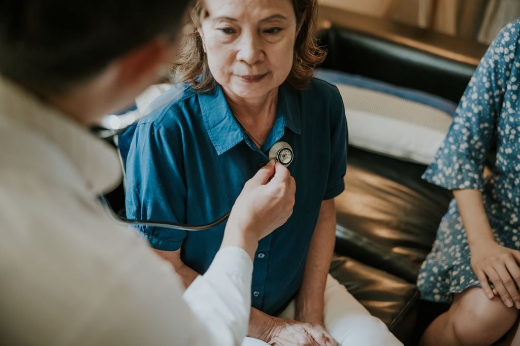 Médico auscultando a una mujer