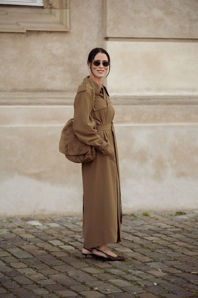 Annabel Rosendahl lleva gabardina larga beige o marrón y bolso marrón de YSL fuera del desfile The Garment durante el tercer día de la Copenhagen Fashion Week (CPHFW) SS25 el 07 de agosto de 2024 en Copenhague, Dinamarca.