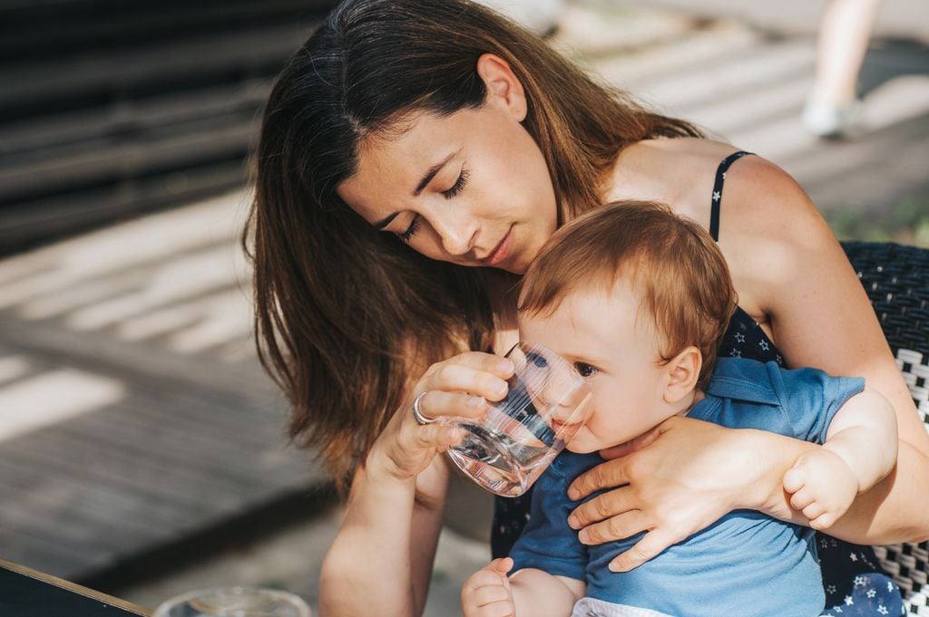 Madre dándole agua a su bebé