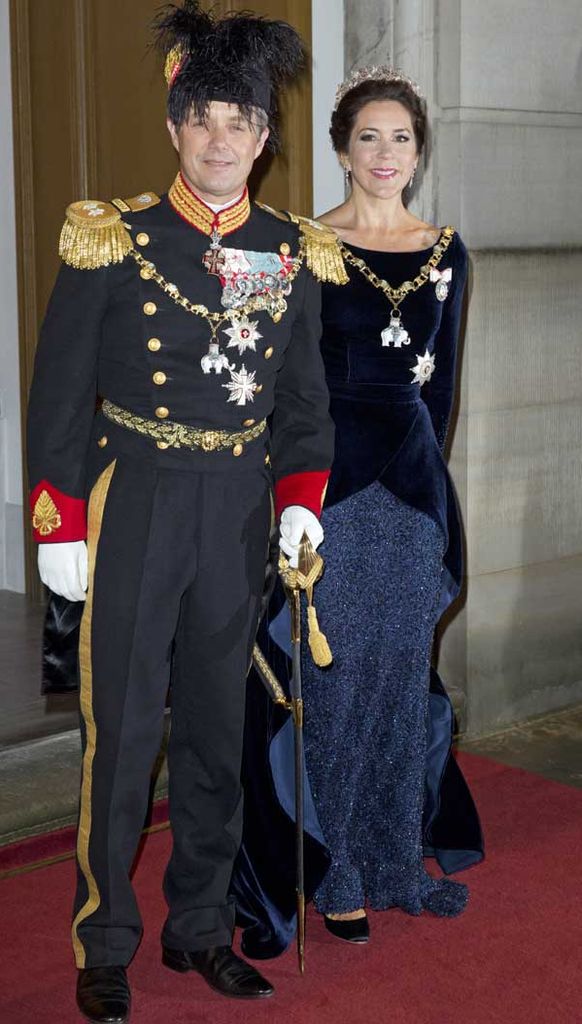 Federico de Dinamarca vestido para la ocasión con el uniforme militar danés junto a su mujer, la princesa Mary, quien eligió un elegante vestido con cuerpo de terciopelo y falda con incrustaciones en pedrería en color azul noche
