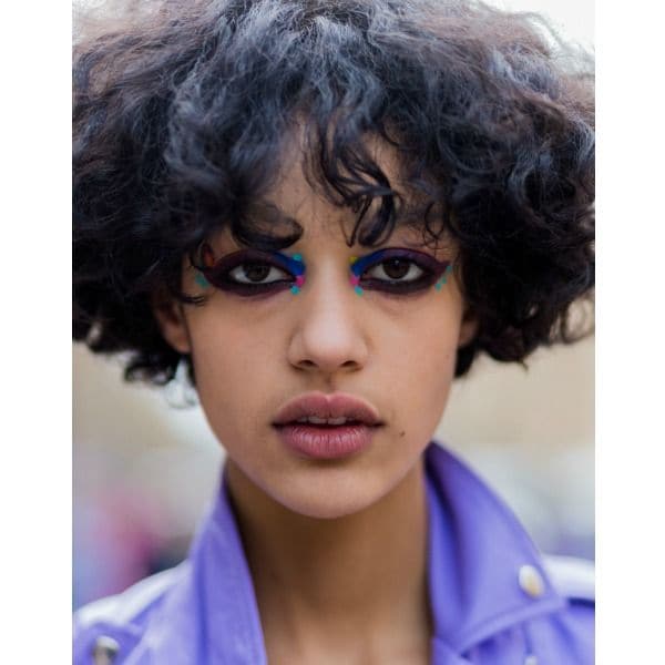 Modelo con maquillaje multicolor de fantasía a la salida del desfile de Fendi en Milán.
