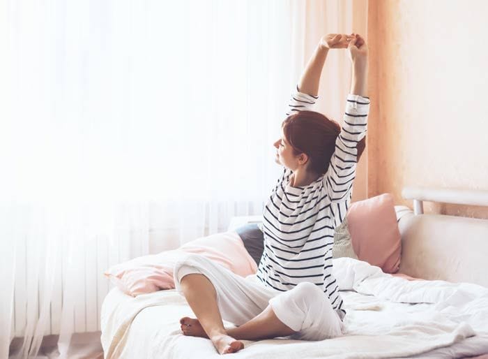 mujer estirando en la cama