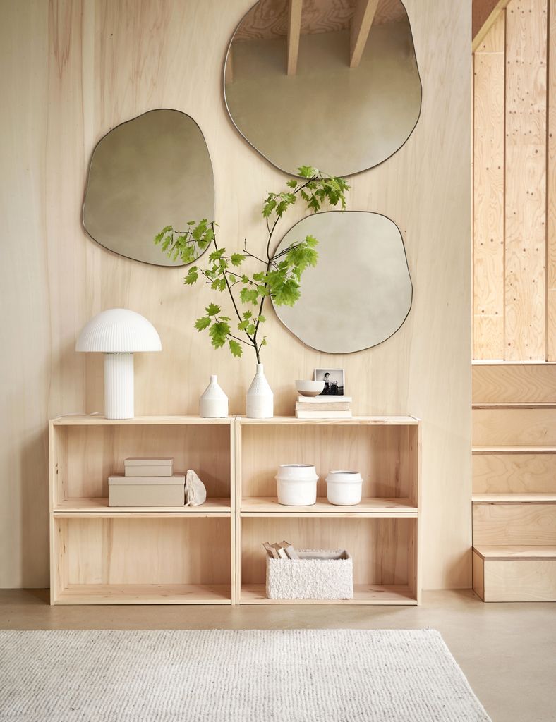 Hallway wall decorated with organically shaped mirrors               