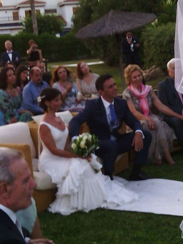 El presentador se casó con un elegante traje de chaqueta azul. La novia, por su parte, estaba radiante con un vestido muy "español", de espalda descubierta y falda de volantes. El pelo lo llevaba recogido en un moño y su ramo era de rosas blancas
