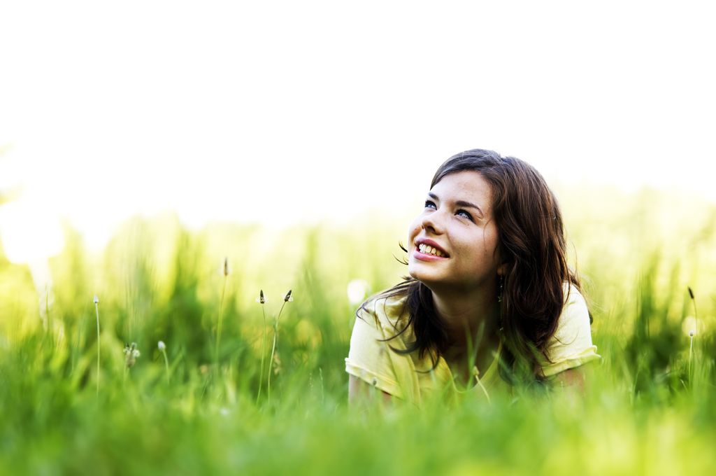 Adolescente feliz tumbada en el campo