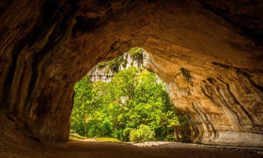 El enorme arco de piedra horadado en la roca sobre el que se asienta la villa de Puentedey.