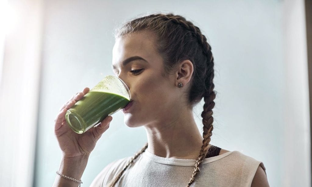 Mujer tomando batido verde tras el ayuno