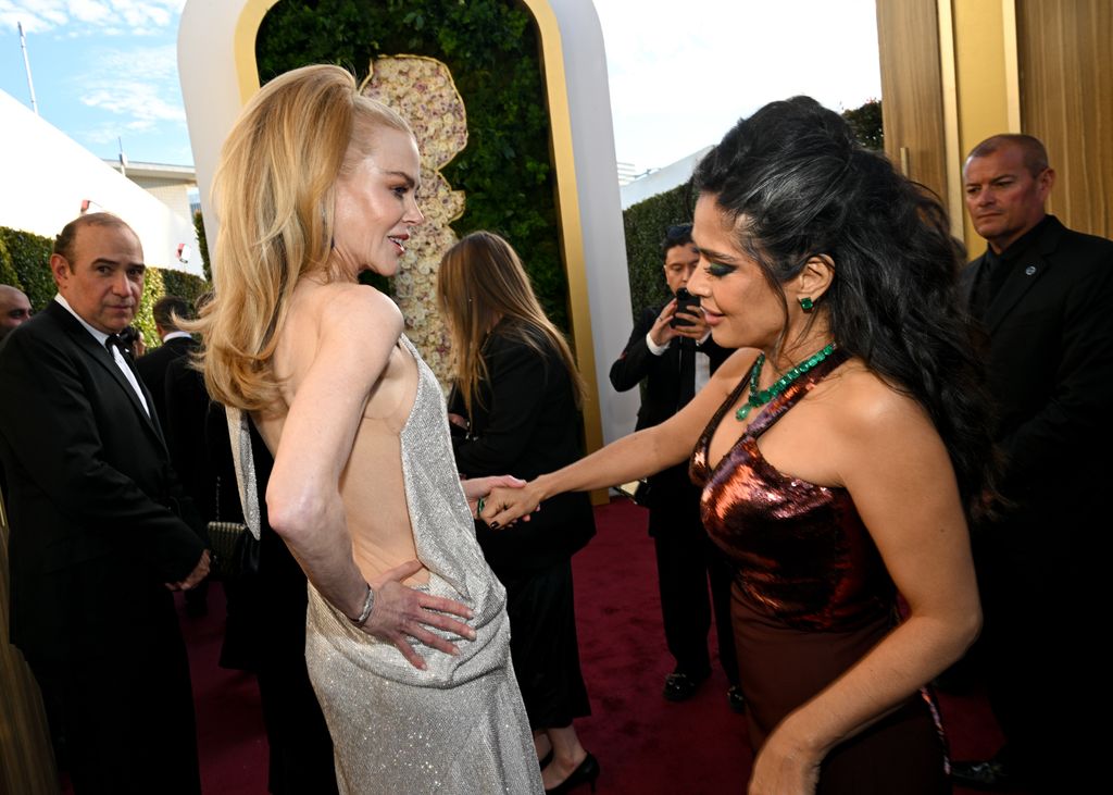 Salma Hayek apreciando el espectacular vestido Balenciaga que usó Kidman para los Golden Globes.