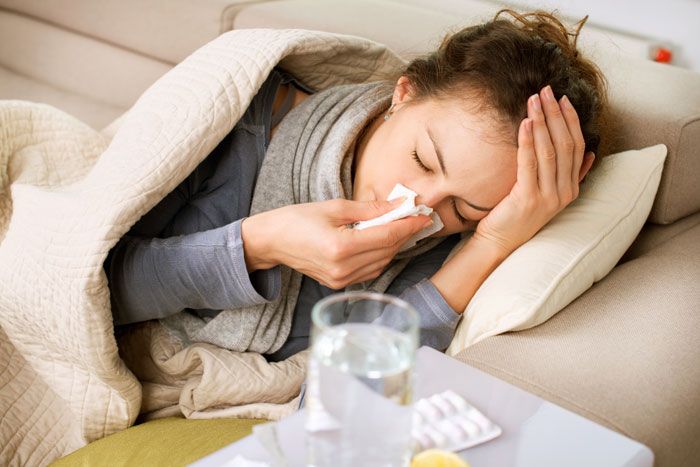 mujer con gripe en la cama