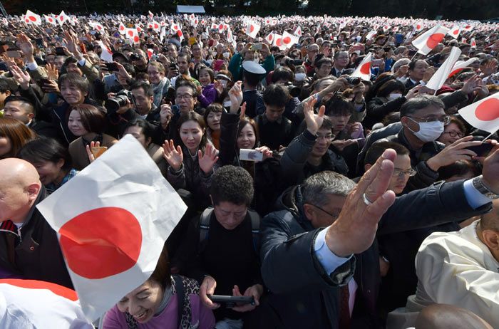 Muchas de las 33.300 personas entusiastas asistieron a la cita de cumpleaños agitando pequeñas banderas nacionales al grito de banzai (¡Viva!)
