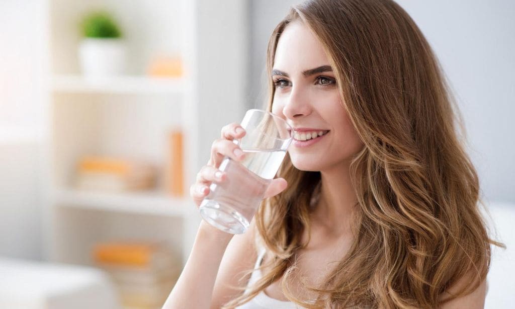 mujer bebiendo un vaso de agua