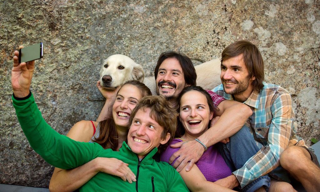 Friends taking selfie with dog against rock