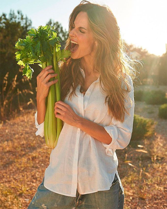 Ariadne Artiles posando en el campo con un manojo de apio