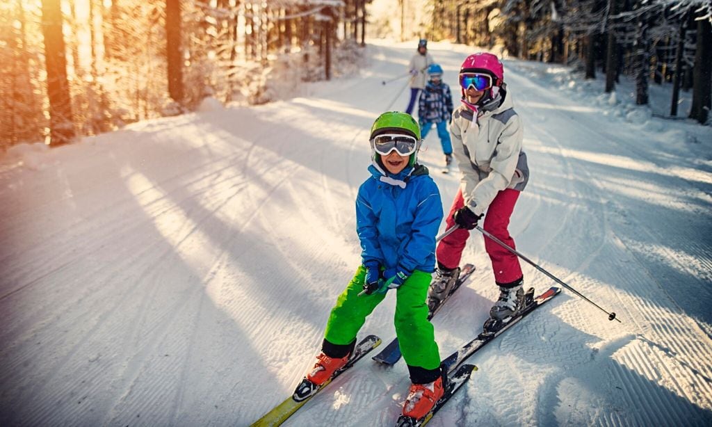 family having fun skiing together on winter day