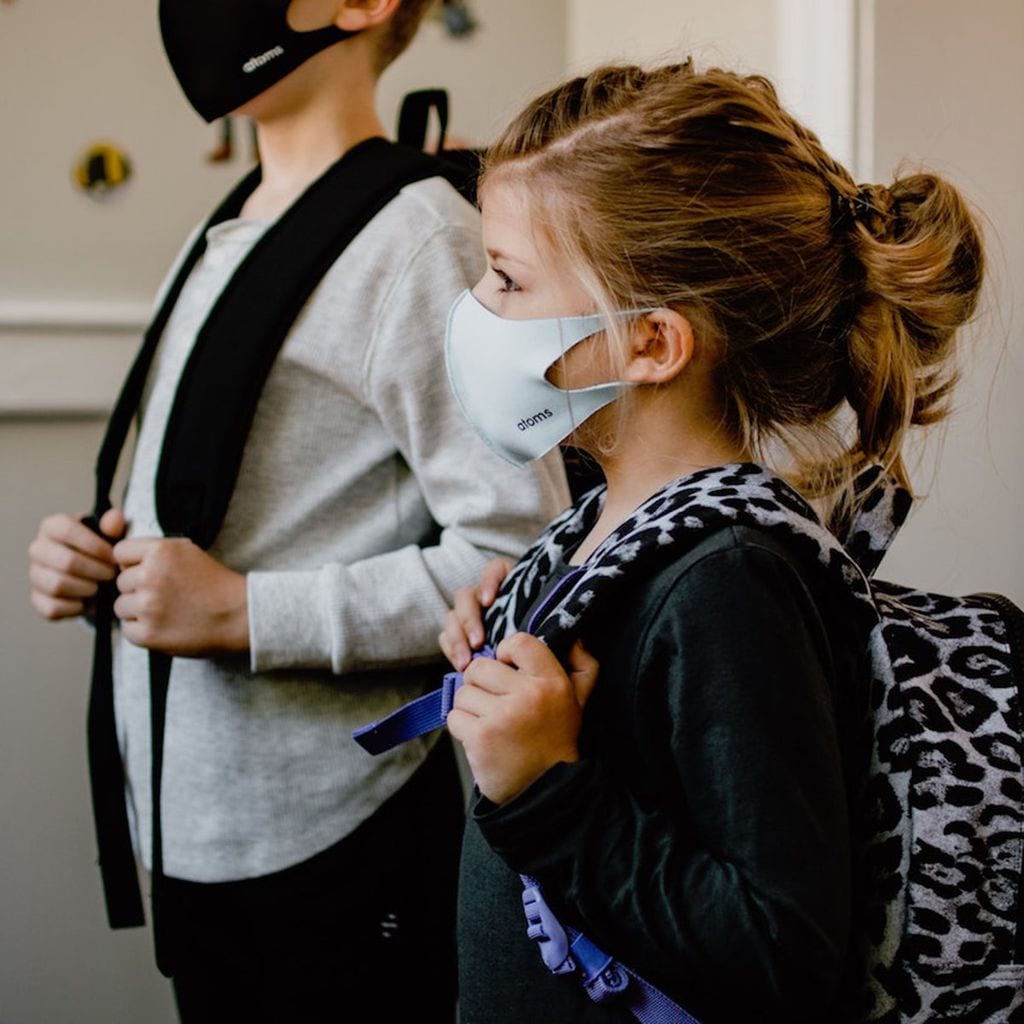 Niños con mascarilla preparados para ir al colegio.