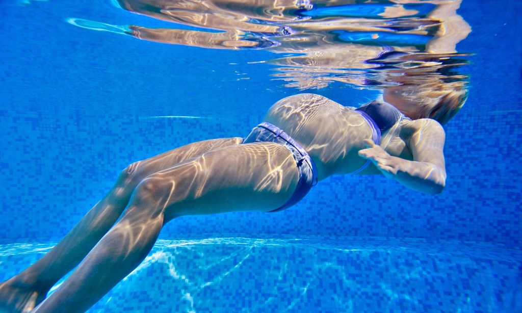 mujer embarazada sumergida en piscina