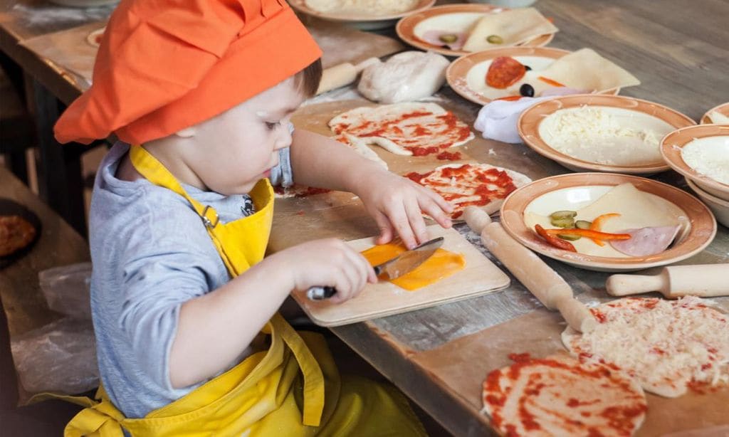 ni o cocinando pizza