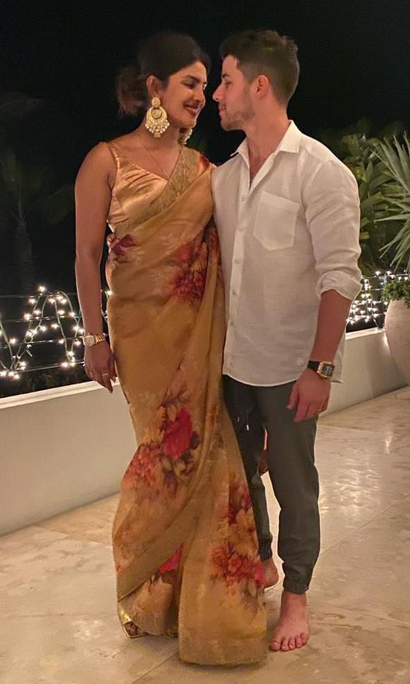 priyanka chopra con vestido dorado junto a nick jonas