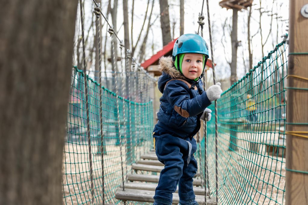 Niño en un parque de aventuras en la naturaleza