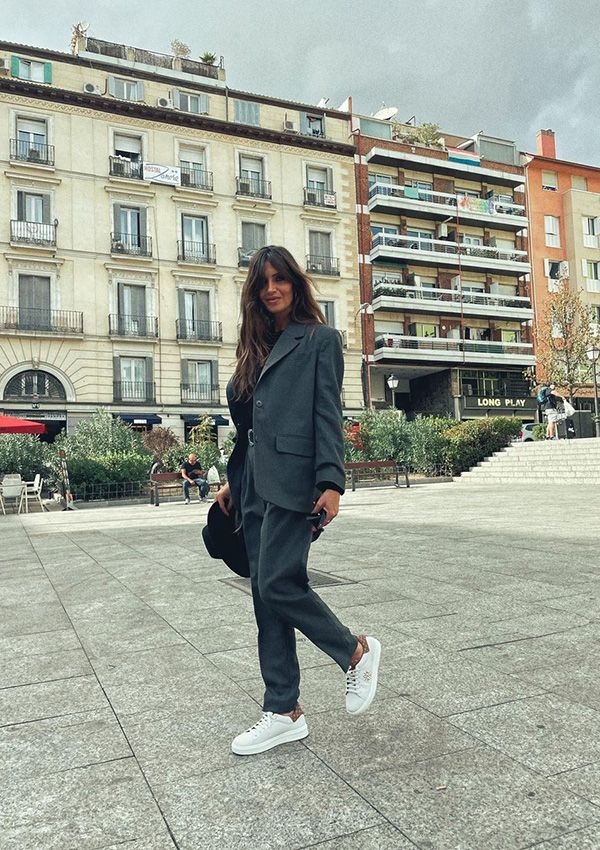 Sara Carbonero con traje gris y zapatillas deportivas blancas