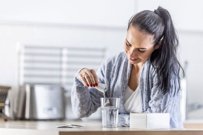 mujer tomando suplementos