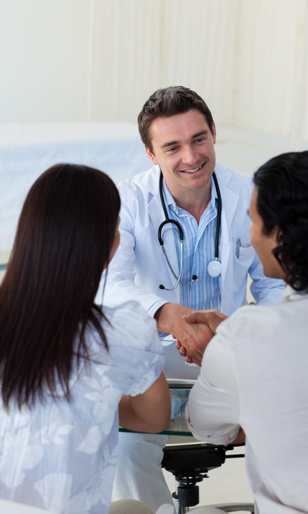 Pareja hablando con doctor en la consulta