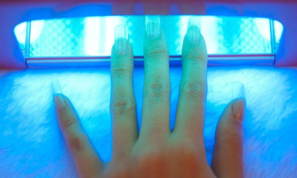 Manicure de gel en mano secadora con rayos UV