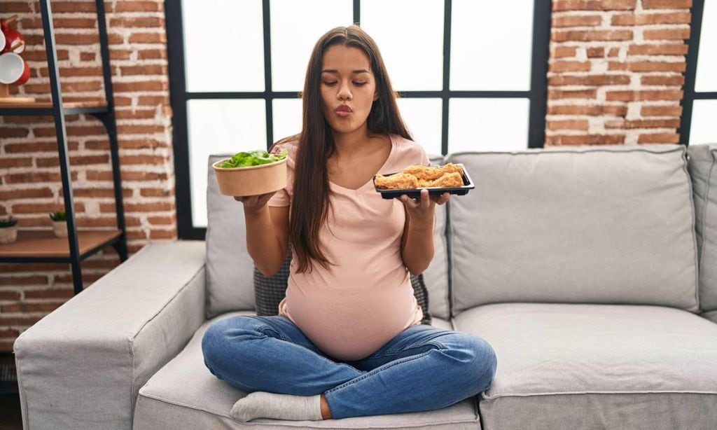 embarazada con comida en las manos