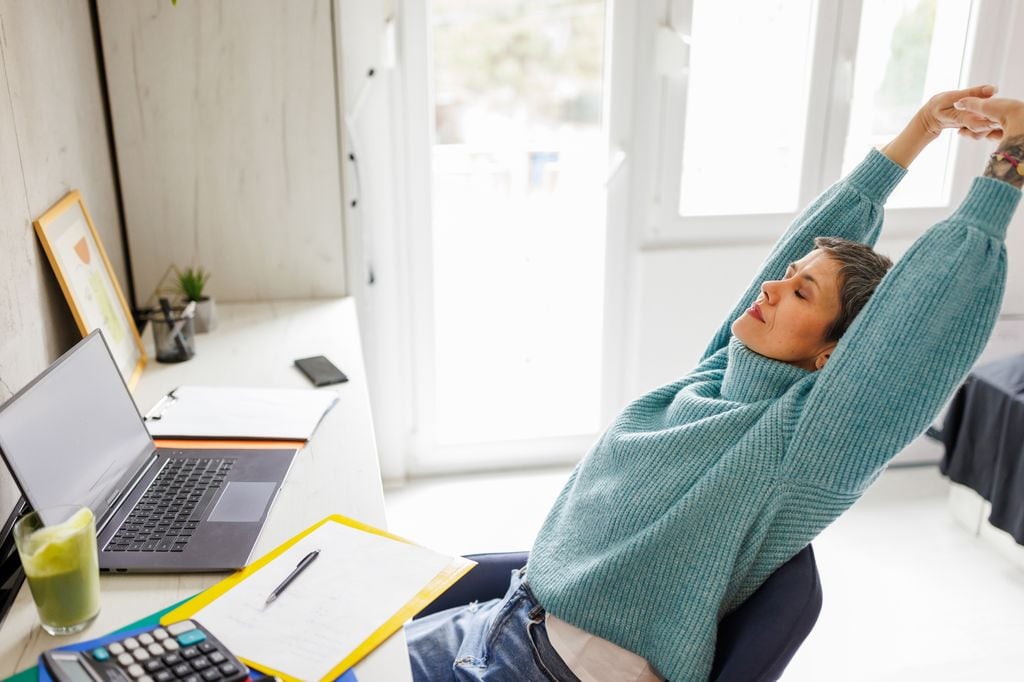 Mujer estirándose en la oficina