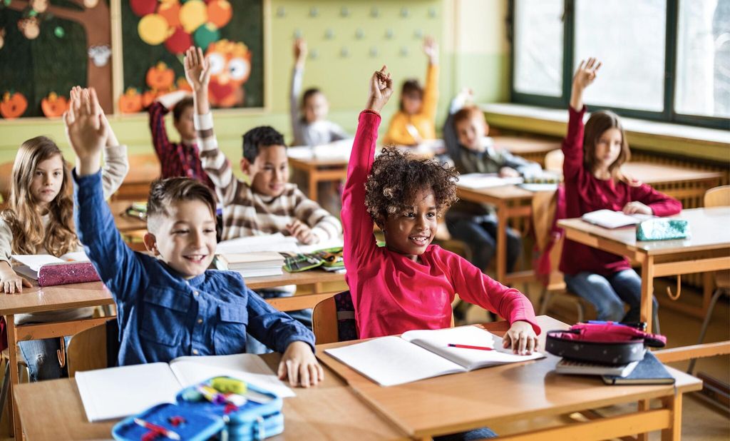 Niños levantan la mano