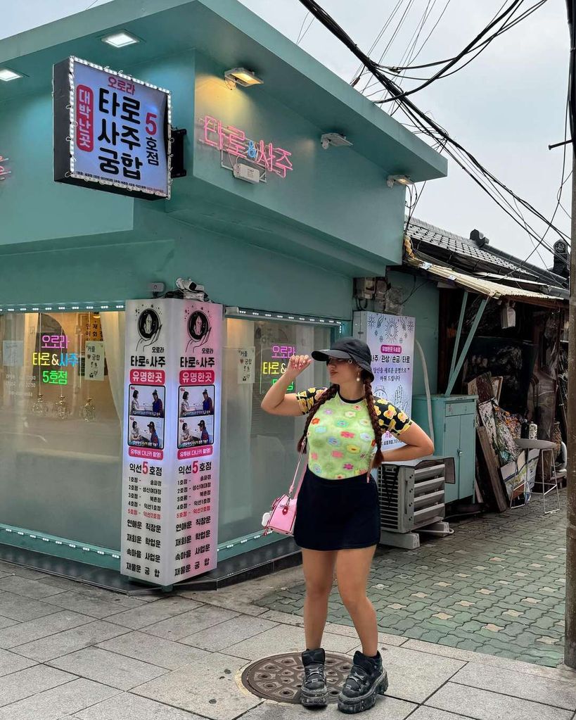 falda negra y camiseta de flores de colores con gorra