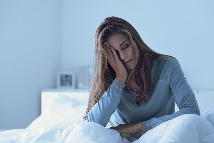 mujer en la cama preocupada