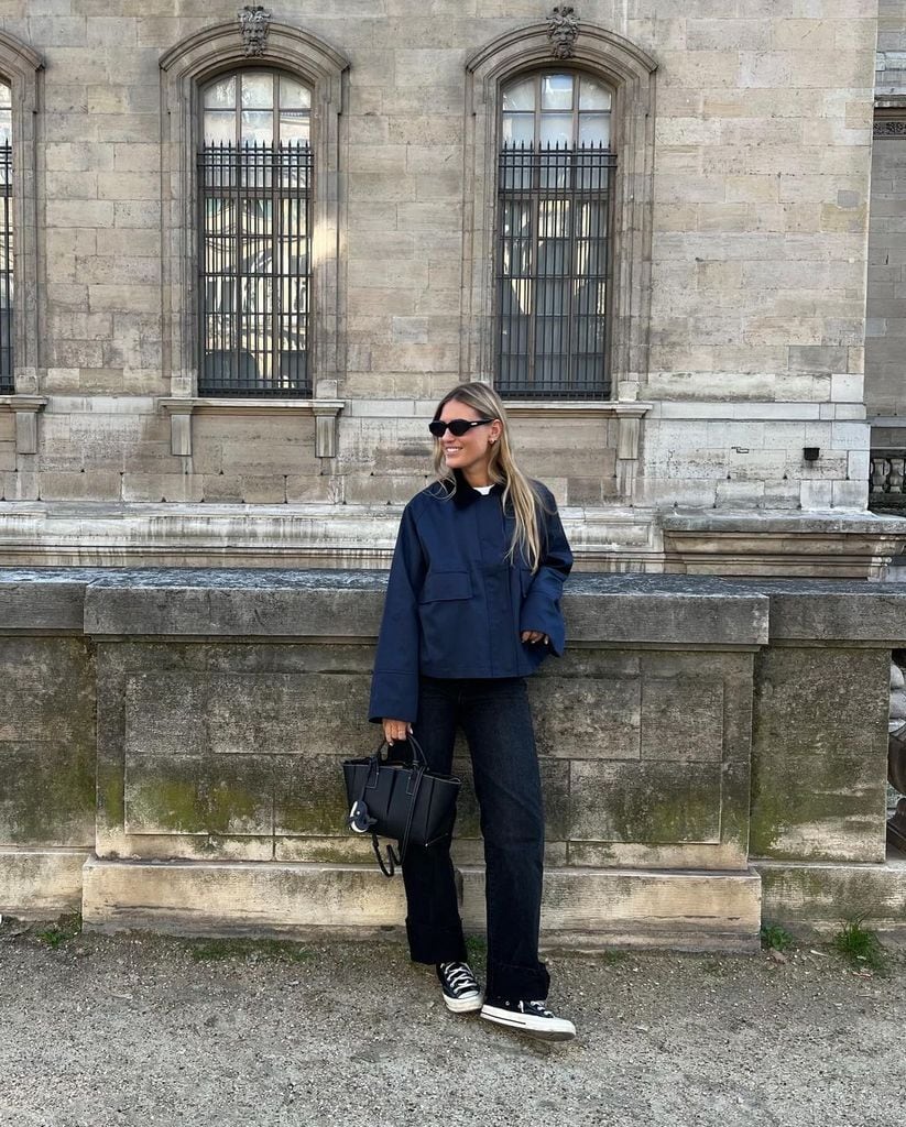 Influencer con look básico, gabardina, vaqueros y zapatillas