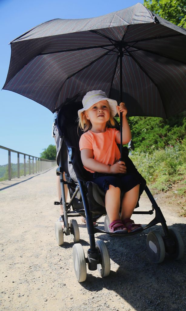 Niña en carro protegiéndose del sol