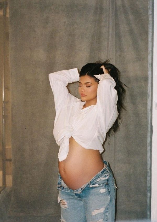 Kylie Jenner embarazada posando con vaqueros y blusa blanca