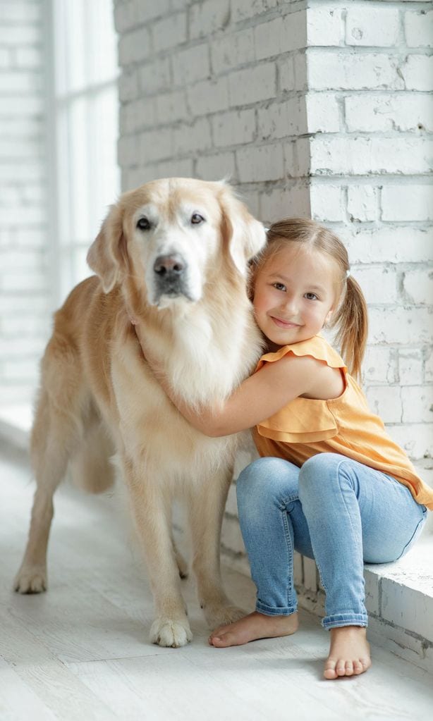 Niña abrazando a perro