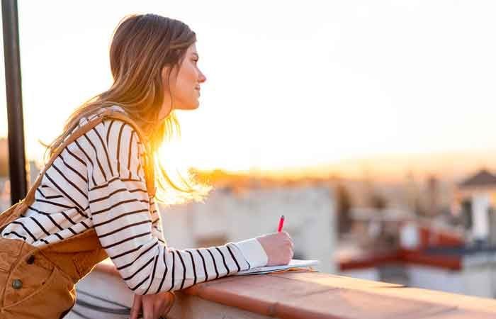 Chica escribe en una terraza