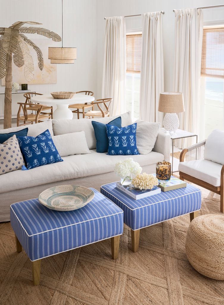 Salón con sofá blanco y puffs azules con rayas