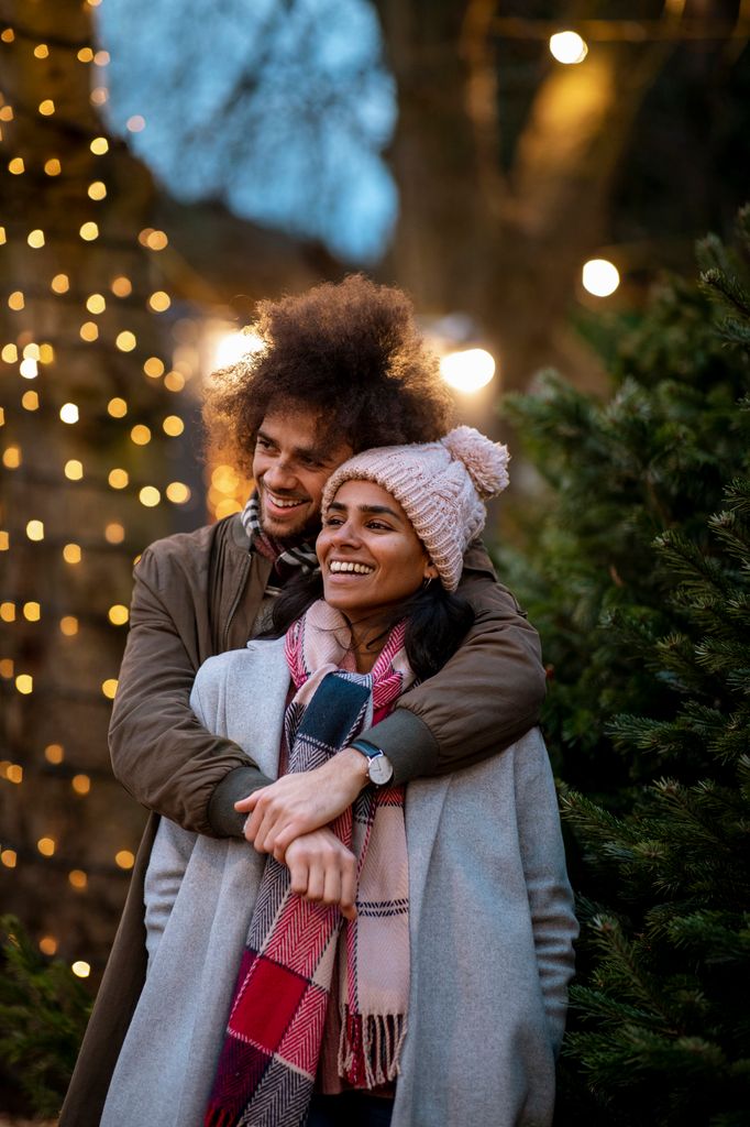 pareja abrazo arbol navidad