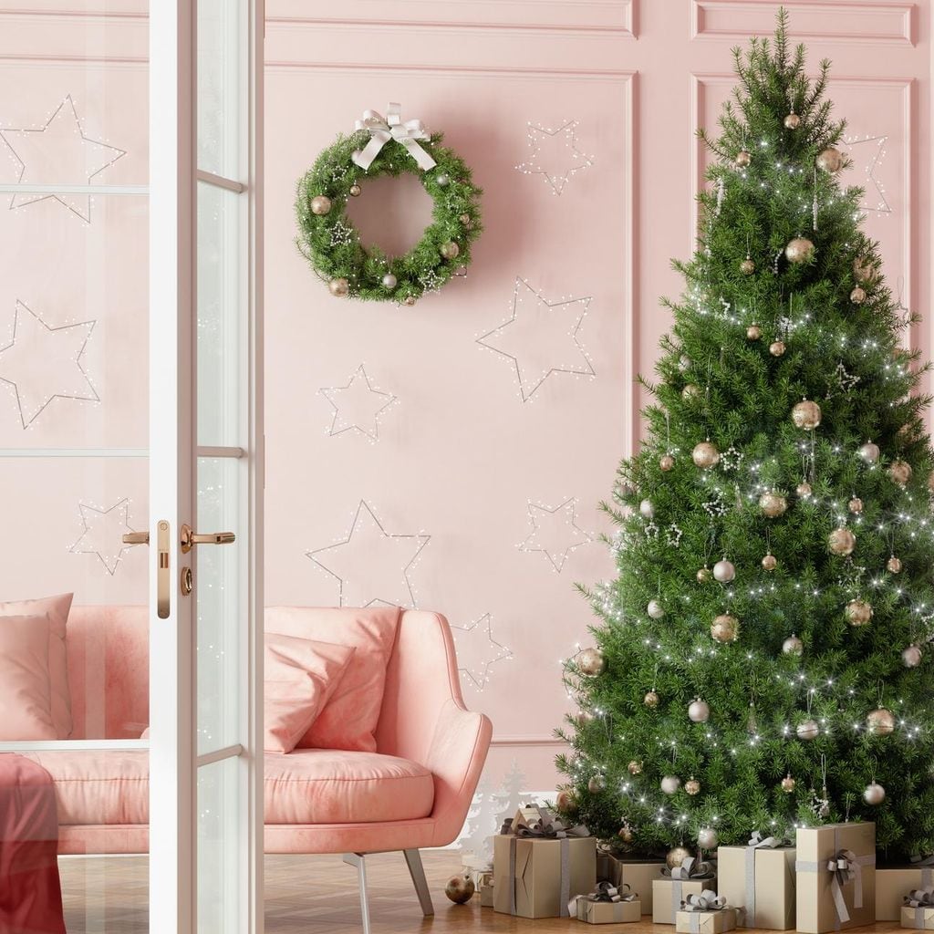 entrance of living room with christmas tree ornaments gift boxes and pink sofa