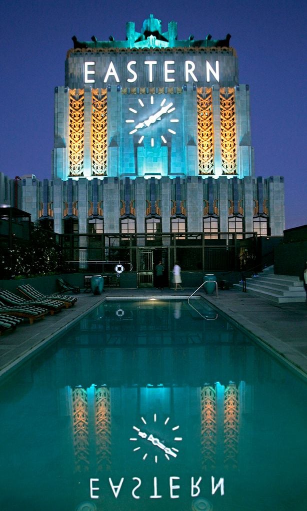 The Eastern Columbia\'s landmark clock tower is lighted every night, its newly restored facade refle