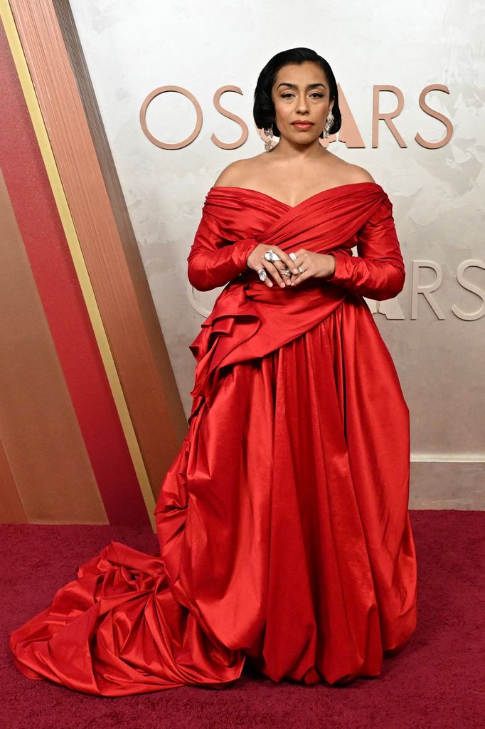 La mexicana Adriana Paz luce radiante en un vestido rojo de escote Bardot firmado por Neithan Herbert. 