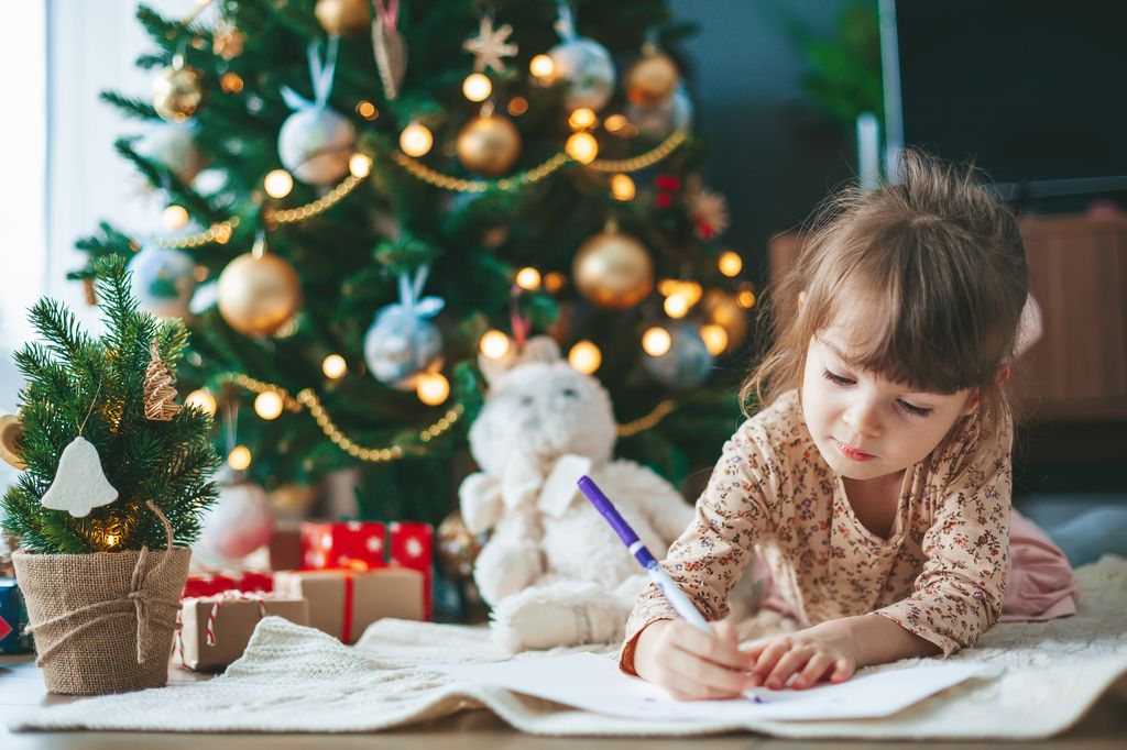 Niña escribiendo la carta a los Reyes Magos