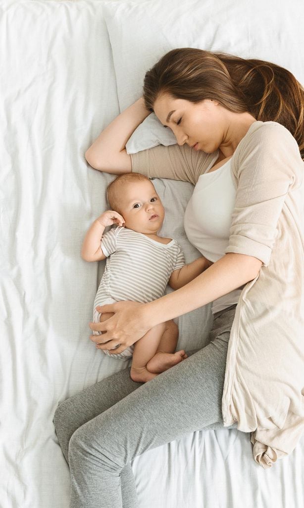 Mamá con su bebé sobre la cama