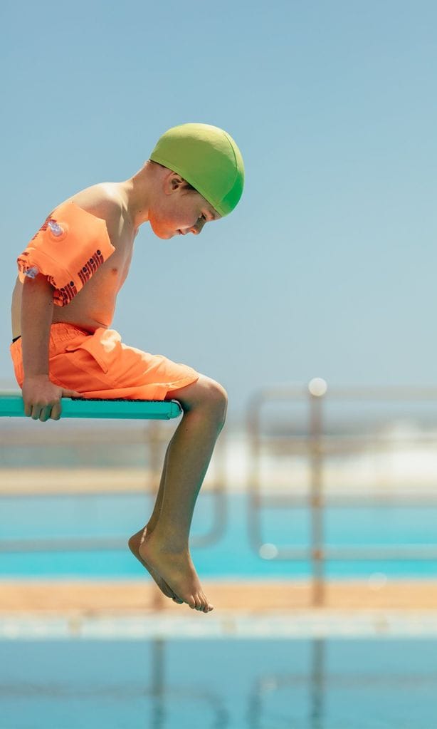 Niño con miedo a meterse en el agua