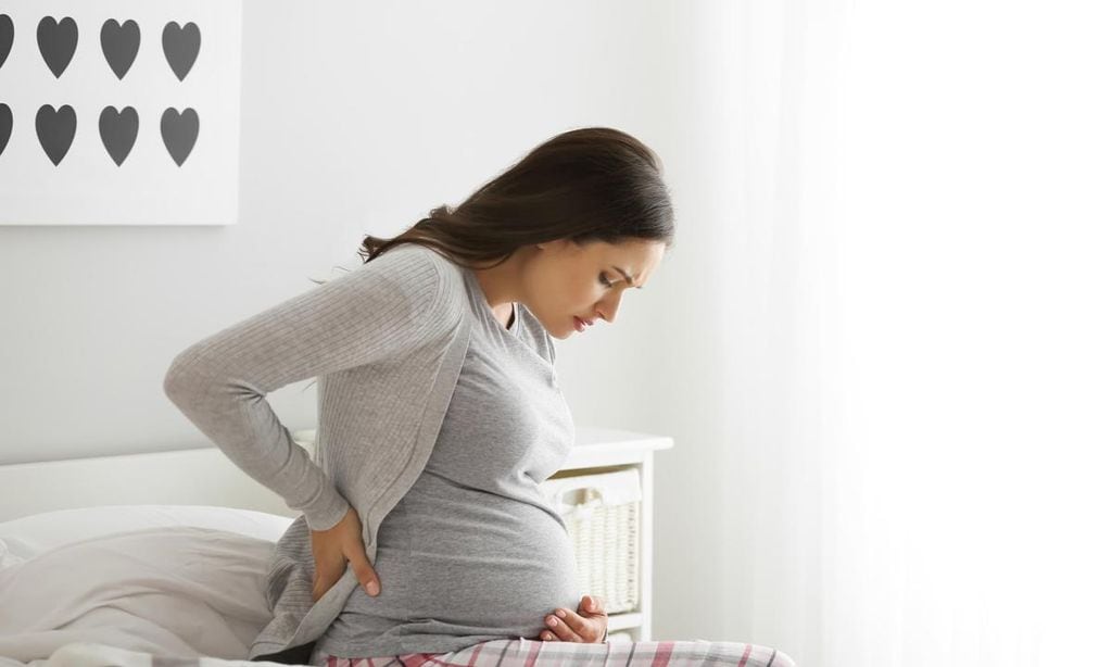 embarazada en la cama con dolor