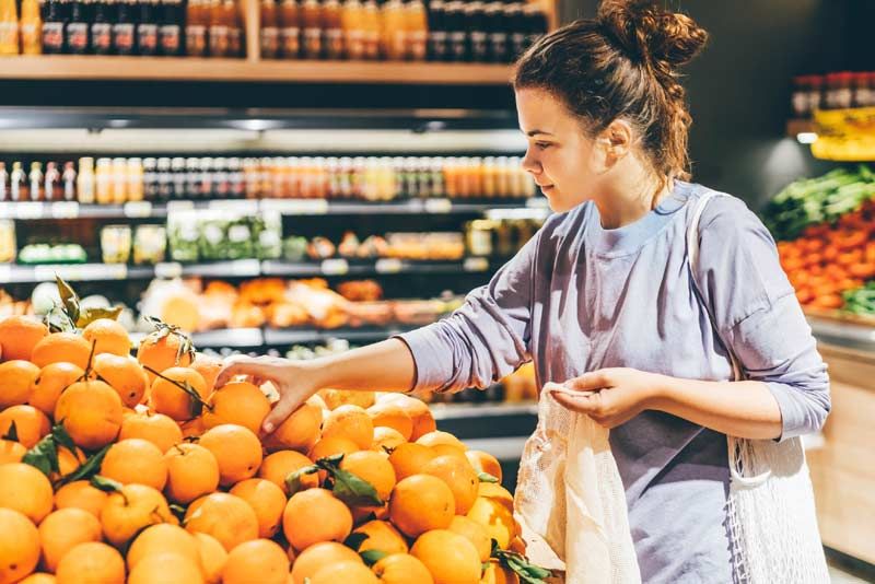 mujer comprando naranjas