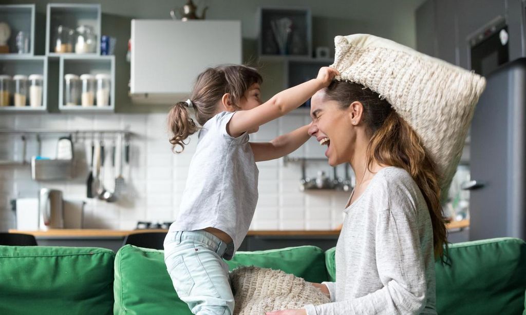 madre e hija jugando en el sof 