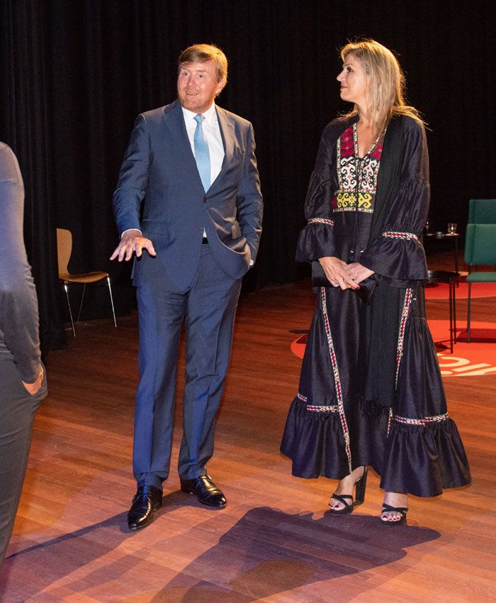 Máxima de Holanda con vestido negro con bordados y sandalias