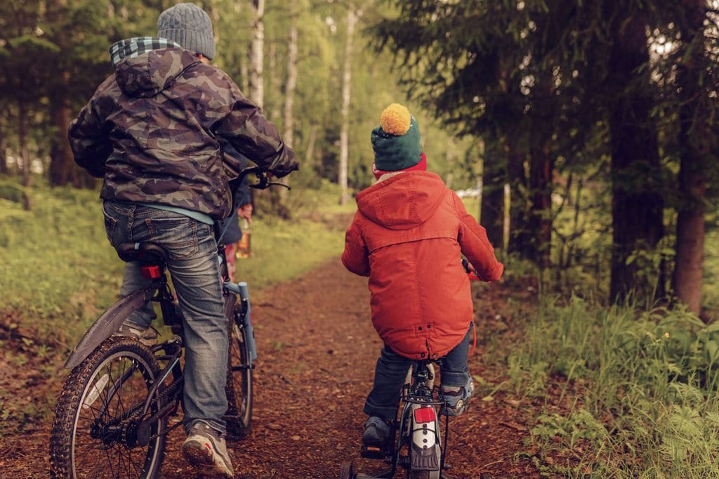 Padre e hijo en bicicleta por la montaña en invierno